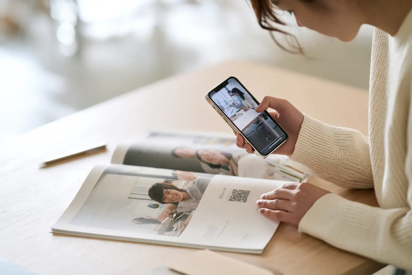 会社説明会で、学生が採用パンフレットに刷られたコードをスマートフォンで読み取り、特設ページの採用動画を開いている様子